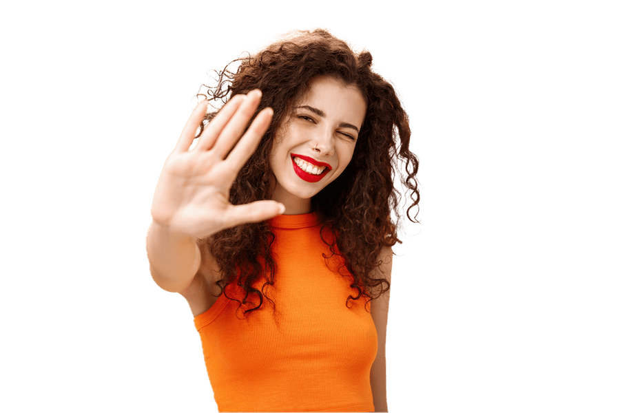 Lachende Frau mit rotem Lippenstift zeigt Stopp-Geste – Symbol für frühzeitige Karieserkennung und minimalinvasive Zahnerhaltung bei der Praxis für Zahnerhaltung Halle Dr. Michaela Strumpski.