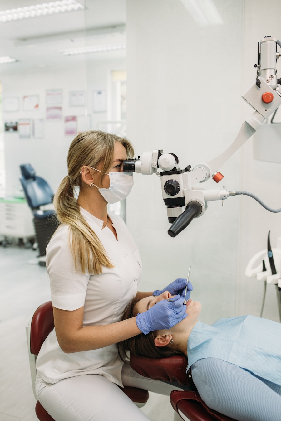 Zahnärztin führt mikroskopgestützte Behandlung bei Patientin durch. Zahnerhaltung Halle – Zahnarztpraxis Dr. Michaela Strumpski spezialisiert auf präzise Endodontie.